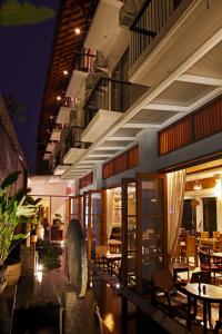 Un restaurante con mesas y sillas por la noche. en Villa Damar Boutique Hotel, en Bandung