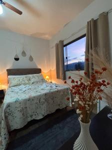 サン・ロケ・デ・ミナスにあるTríade Chalé da Canastra 1のベッドルーム1室(ベッド1台付)、花瓶1本