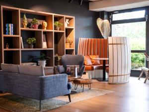 a living room with two chairs and a table at Novotel Bordeaux Mérignac in Mérignac