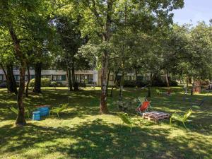 a park with chairs and trees with a building in the background at Novotel Bordeaux Mérignac in Mérignac