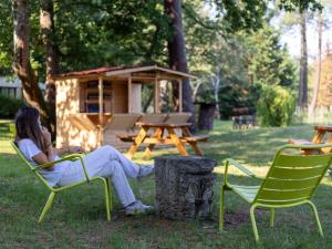 a woman sitting in a chair in the grass at Novotel Bordeaux Mérignac in Mérignac