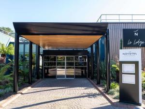 a entrance to a building with a sign in front at Novotel Rouen Sud Zenith Parc Expo in Saint-Étienne-du-Rouvray