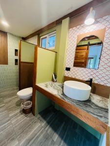 Un baño con lavabo, inodoro y espejo. en Chomjan Resort, en Ko Phayam