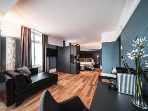 - un salon avec un canapé noir et un lit dans l'établissement Royal St. Georges Hotel Interlaken - MGallery Collection, à Interlaken