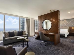 a hotel room with a couch and a bed and a mirror at Swissotel Chicago in Chicago +124 photos