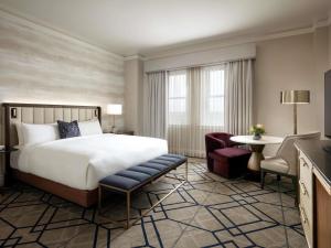a hotel room with a bed and a chair and a table at Fairmont Hotel Macdonald in Edmonton