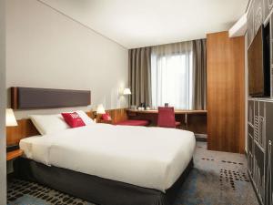 a hotel room with a large bed and a desk at Ibis Ambassador Myeongdong in Seoul