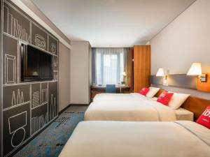 a hotel room with two beds and a flat screen tv at Ibis Ambassador Myeongdong in Seoul +73 photos