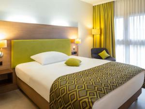 a hotel room with a large bed and a window at Hotel Mercure Graz City in Graz +97 photos