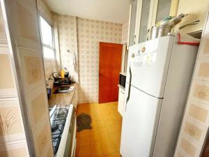 eine Küche mit einem weißen Kühlschrank und einem Herd in der Unterkunft Apartamento 2 Quadras da Praia da Enseada in Guarujá