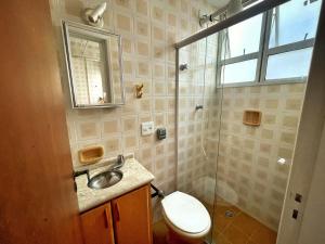 ein Badezimmer mit Toilette, Waschbecken und Dusche in der Unterkunft Apartamento 2 Quadras da Praia da Enseada in Guarujá