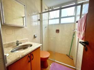 ein Badezimmer mit Waschbecken und Dusche in der Unterkunft Apartamento 2 Quadras da Praia da Enseada in Guarujá