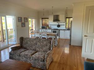 ein Wohnzimmer mit Sofa und Tisch in der Unterkunft Peppergrove Cottage in Berry