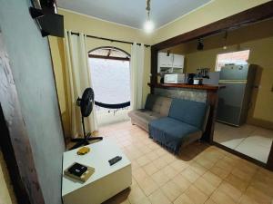 een woonkamer met een bank en een keuken bij Chalé 2 em Ilhabela in Ilhabela +13 foto's