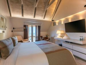 a bedroom with a large bed with a flat screen tv at Sofitel Legend Santa Clara Cartagena in Cartagena de Indias +243 photos