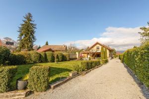 a driveway leading to a house with hedges at Maison Ondine - Logement familial à deux pas du lac et des commerces in Saint-Jorioz