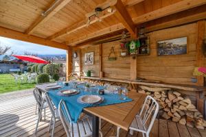 a wooden table and chairs on a wooden deck at Maison Ondine - Logement familial à deux pas du lac et des commerces in Saint-Jorioz