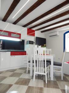 a kitchen with white cabinets and a table and chairs at Karmen's Apartment One in Split