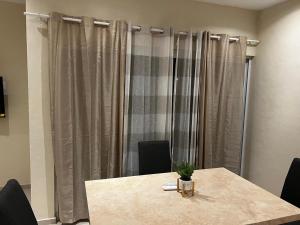 a table and chairs in a room with curtains at Apartamento Valle in Puerto Vallarta +8 photos