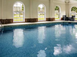 a large swimming pool with blue water in a building at Mercure Haydock Hotel in Haydock