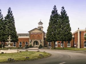 a large brick building with a fountain in front of it at Mercure Haydock Hotel in Haydock