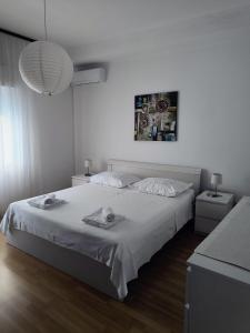 - une chambre blanche avec un grand lit et une lampe dans l'établissement Apartments by the sea Sumpetar, Omis - 17895, à Sumpetar