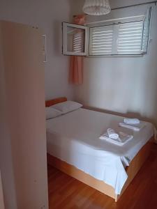 - une petite chambre avec un lit blanc et une fenêtre dans l'établissement Apartments by the sea Sumpetar, Omis - 17895, à Sumpetar