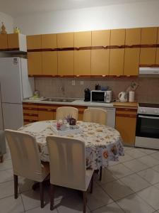 une cuisine avec une table avec des chaises et une table et une cuisine avec une table dans l'établissement Apartments by the sea Sumpetar, Omis - 17895, à Sumpetar 12 autres photos