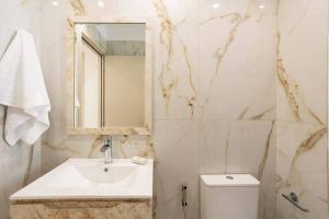 a white bathroom with a sink and a toilet at Astir Apartments Kalamata in Kalamata +59 photos
