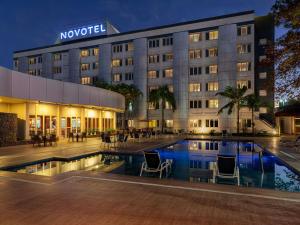 a hotel with a swimming pool in front of a building at Novotel Sao Jose dos Campos in São José dos Campos