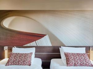 a bedroom with two beds and a wooden headboard at Novotel Sao Jose dos Campos in São José dos Campos