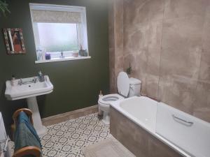 a bathroom with a tub and a toilet and a sink at Bishop bed and breakfast in Bishop Auckland