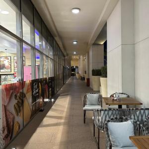 Un pasillo con sillas y mesas en un edificio. en Bellevue Towers Luxurious Burj Khalifa, Full Downtown & Old-town Views, en Dubái