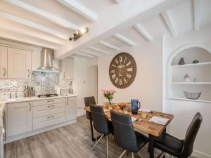 a kitchen with a table and a clock on the wall at 3 Bed in Thornton-Le-Dale 82856 in Thornton Dale