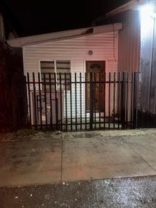 una cerca negra frente a una casa blanca en Cabañas Angeles, en Punta Arenas