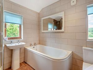 a bathroom with a tub and a sink and a mirror at 3 Bed in Hawkshead Village LLH48 in Hawkshead +16 photos