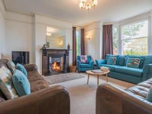 a living room with blue furniture and a fireplace at 6 Bed in Braithwaite SZ044 in Braithwaite