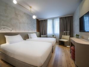 a hotel room with two beds and a desk at Maison Sofia - MGallery in Sofia +190 photos