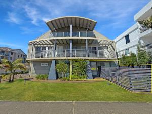 ein großes Haus mit einem Balkon an der Seite in der Unterkunft Seachange Apartment 1 in Hawks Nest