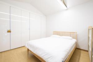 a white bedroom with a bed and white cabinets at Paran Garden in Damyang