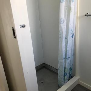 a small room with a shower curtain in it at The Bivvy at Hutt Central in Lower Hutt