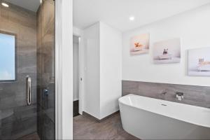 a bathroom with a white tub and a shower at 10 William Jones Place in Hanmer Springs +21 photos