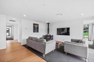 a living room with two couches and a tv at 10 William Jones Place in Hanmer Springs