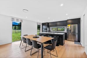 a kitchen with a wooden table and chairs at 10 William Jones Place in Hanmer Springs