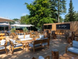 a patio with tables and chairs and a restaurant at Novotel Rouen Sud Zenith Parc Expo in Saint-Étienne-du-Rouvray