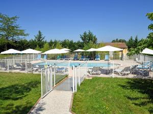 a pool with tables and chairs and umbrellas at ibis Sisteron in Sisteron