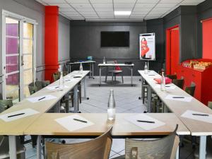 a conference room with tables and chairs and a tv at ibis Sisteron in Sisteron +126 photos