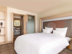 阿比让Novotel Abidjan Plateau的酒店房间里的一张白色大床 更多102张照片