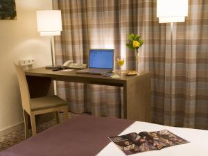 a desk in a hotel room with a laptop on it at Mercure Hotel Frankfurt Eschborn Ost in Eschborn
