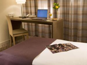 a room with a desk with a laptop and a chair at Mercure Hotel Frankfurt Eschborn Ost in Eschborn